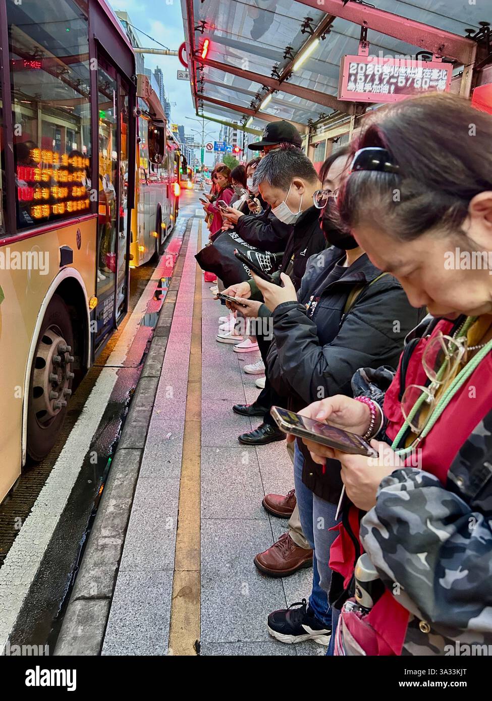 Taipei, Taiwan, Crowd People, Waiting on Line for Boarding Public Bus at Station on Street, Looking at Smart Phones, tech products, urban crowds - Smartphone Captured Stock Image