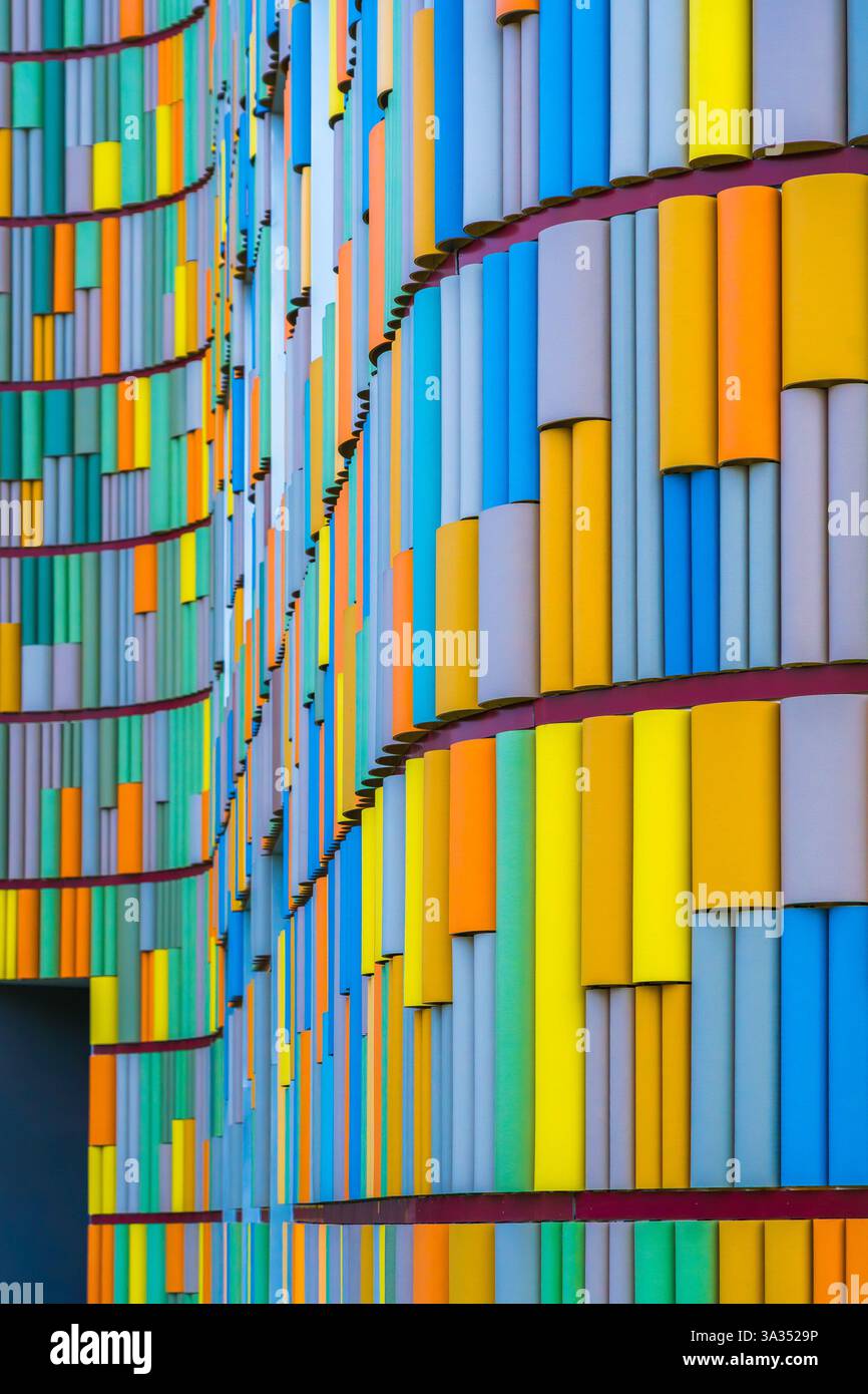 A striking image depicting the vivid, multicolored facade of a contemporary building, showcasing a dynamic array of vertical panels in various hues. Stock Photo