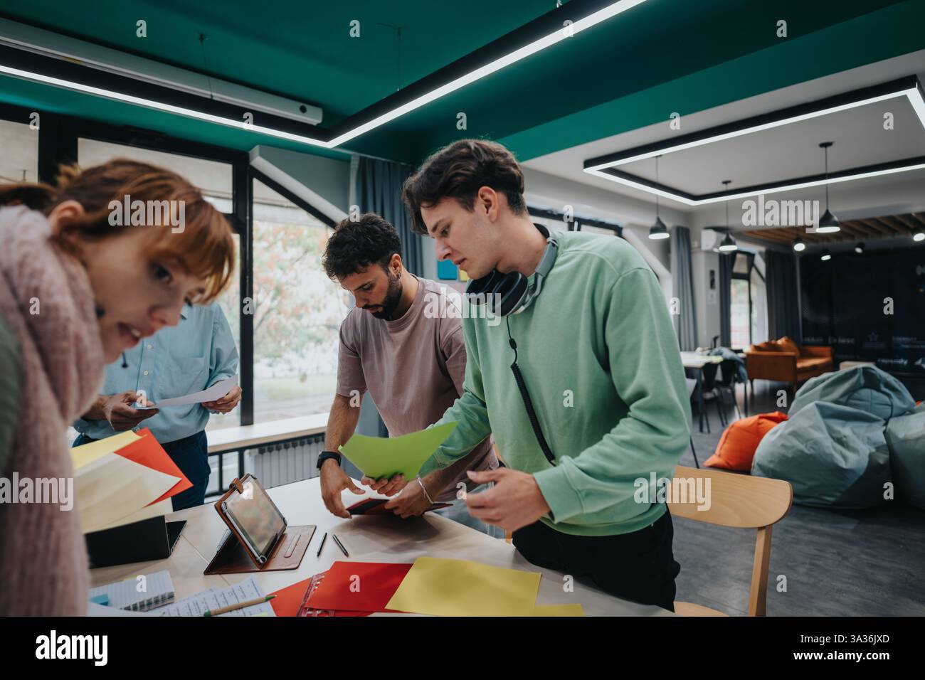 College students collaborating on a project in modern classroom with guidance Stock Photo