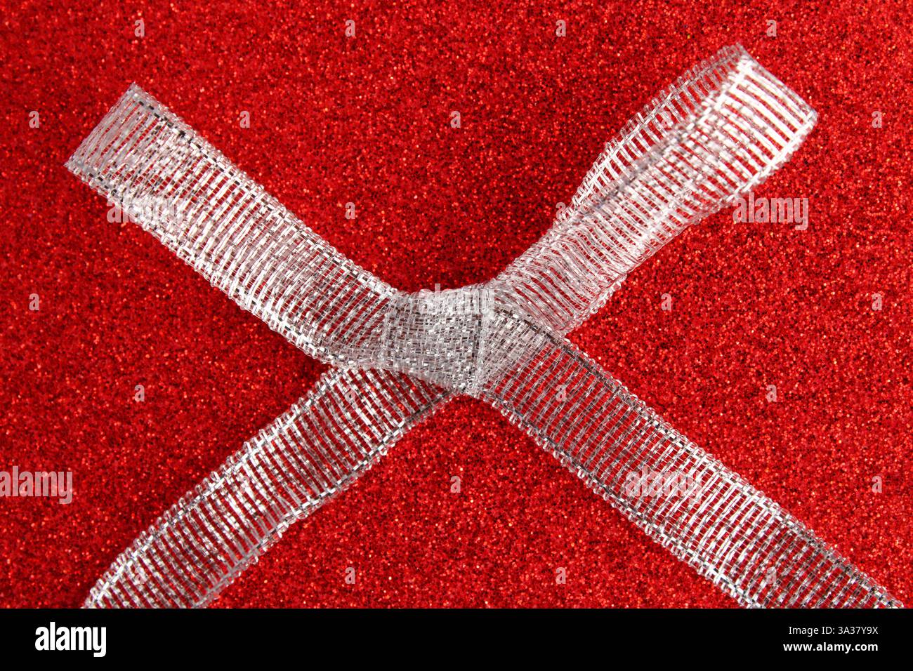 Large silver glitter bow on a red background Stock Photo