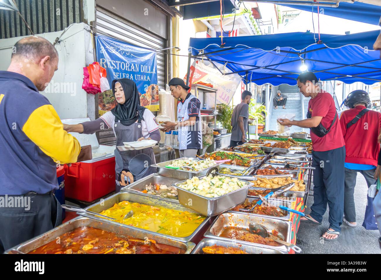 food arranged in metal trays, a buffet-style or 'point and choose' service common in Malaysian cuisine., Dilla restaurant, Kuala Lumpur, Malaysia Stock Photo