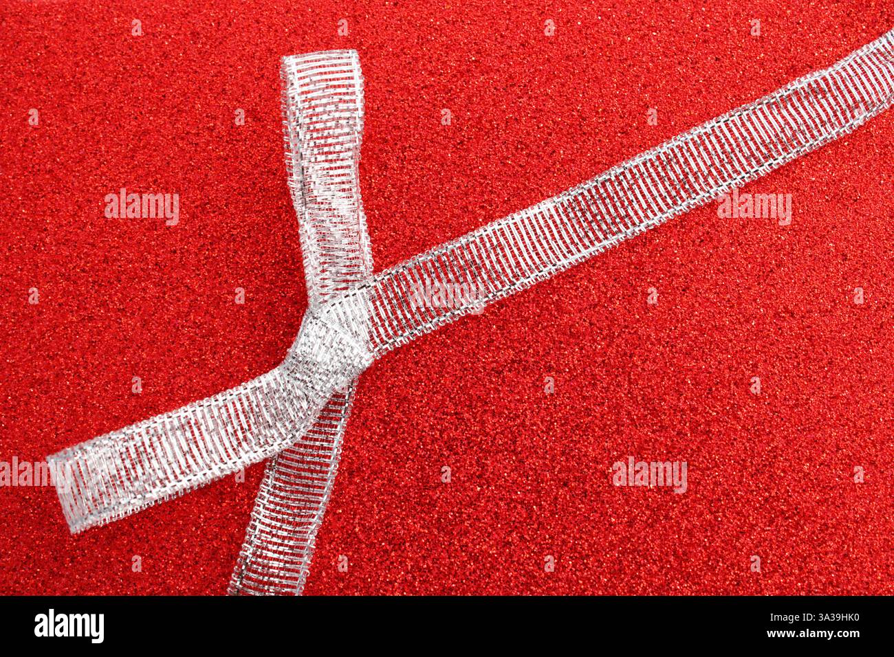 Silver glitter bow on a red background Stock Photo
