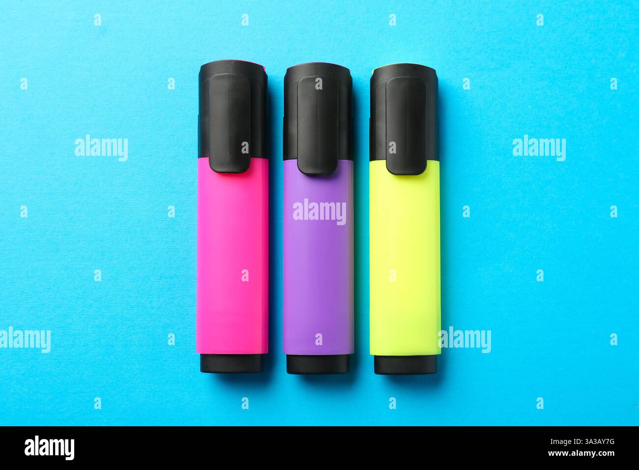 Bright highlighters on light blue background, flat lay Stock Photo