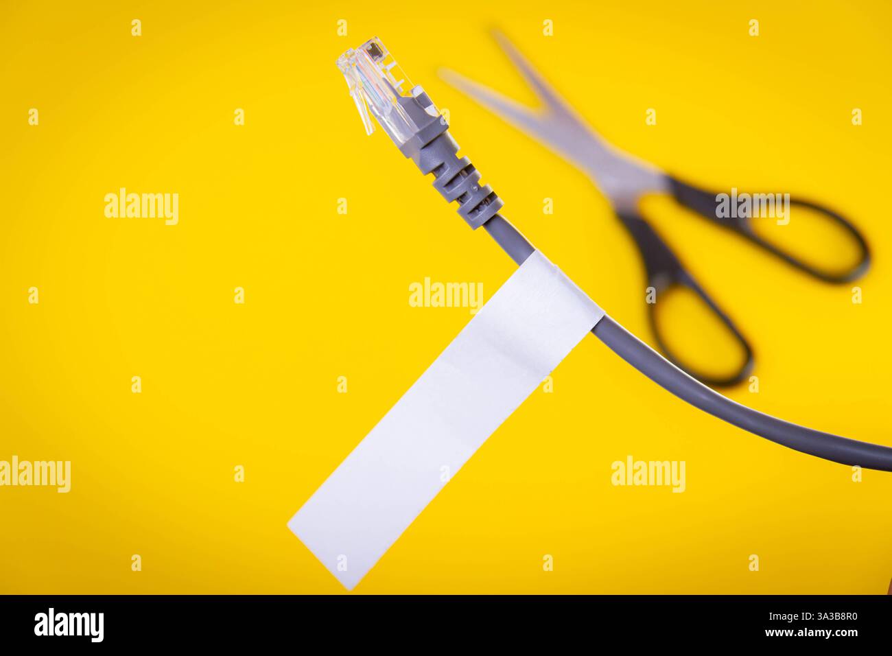 Internet cable and scissors cut it. Disconnection of Internet network. Connection to World Wide Web.. Stock Photo