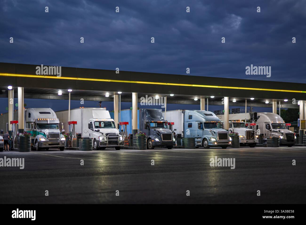 Professional big rig semi trucks with turned on headlights and loaded ...