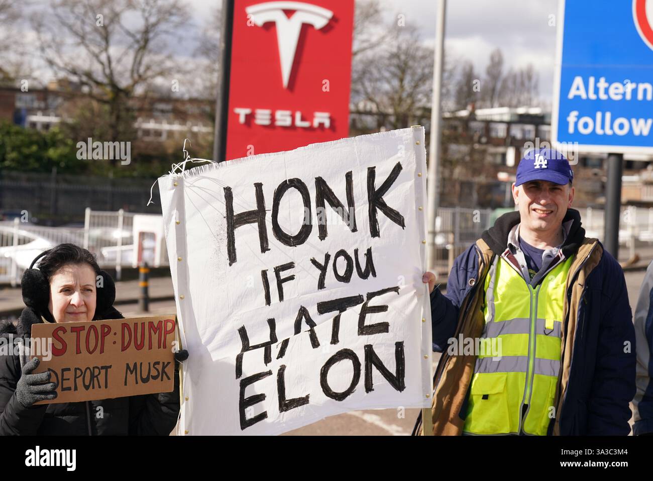 People take part in a protest outside of the Tesla centre at Park Royal ...