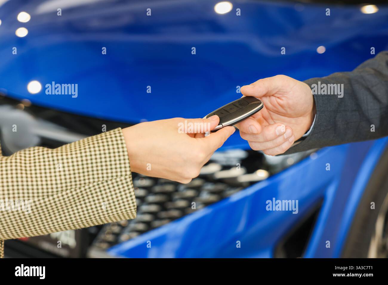 Saleswoman giving car key to client in salon, closeup Stock Photo - Alamy