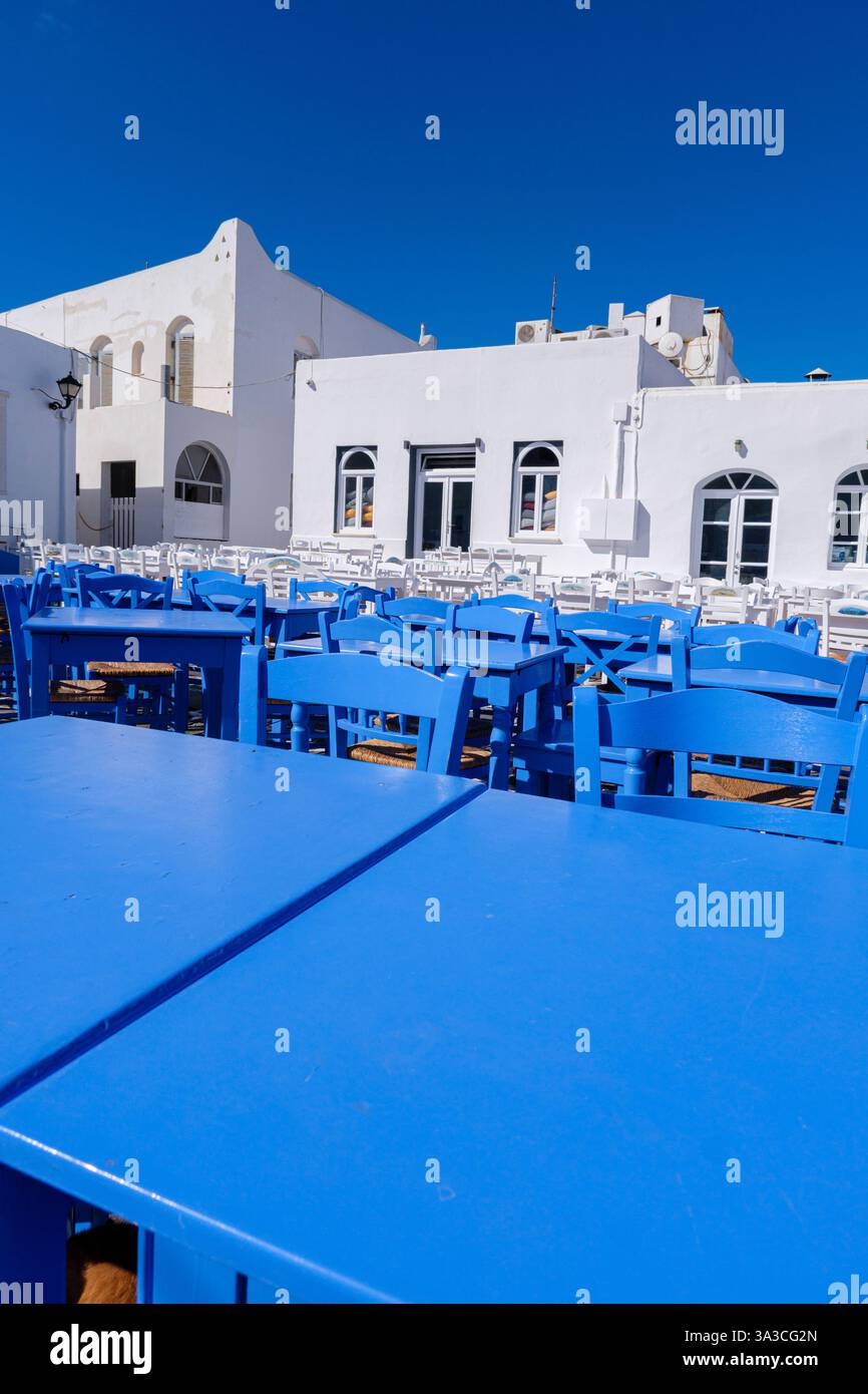 A charming scene in Naoussa with blue tables and chairs set up in front ...