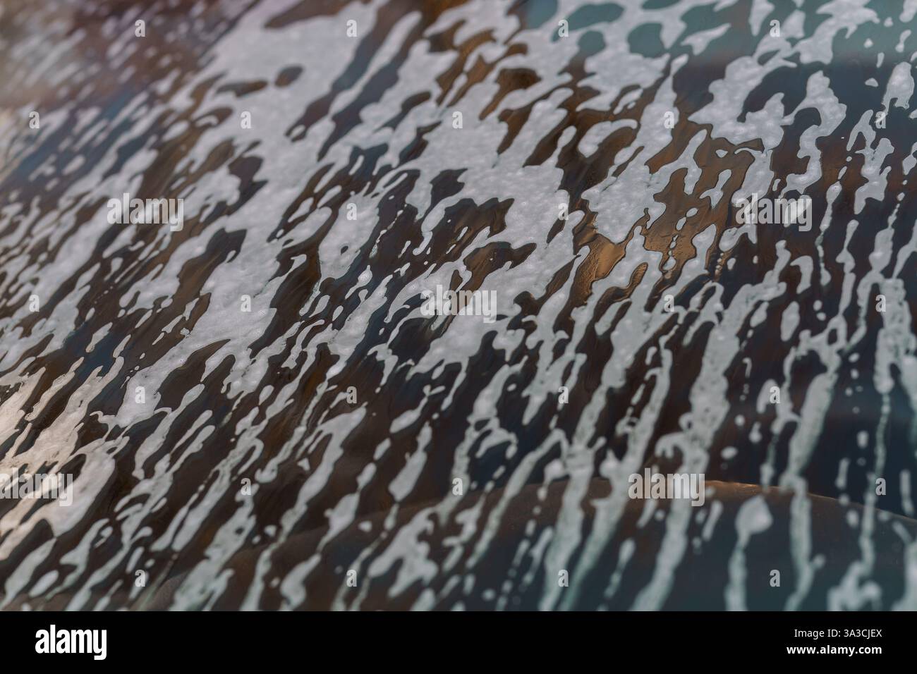 Abstract Close-Up Texture of White Foam on Glass Surface with Dark Background. Stock Photo
