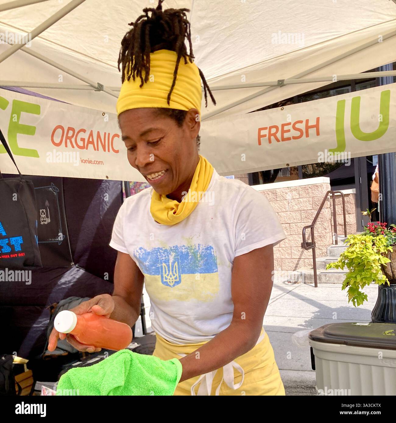 A woman sells freshly squeezed juice at a street market in Sarasota, Florida, USA - Smartphone Captured Stock Image