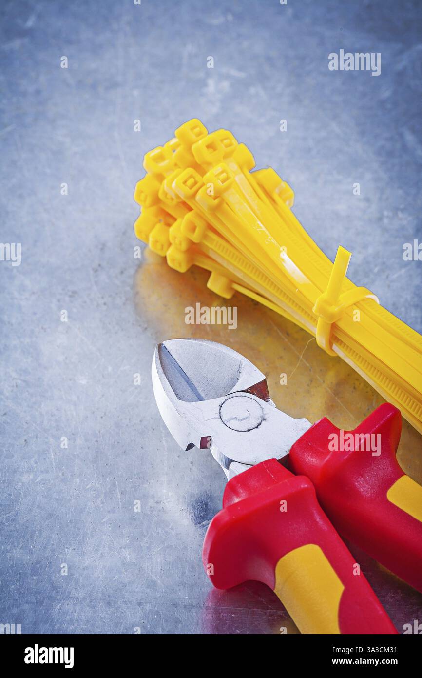 Wire-cutter plastic self-locking cable ties on metallic background construction concept Stock Photo