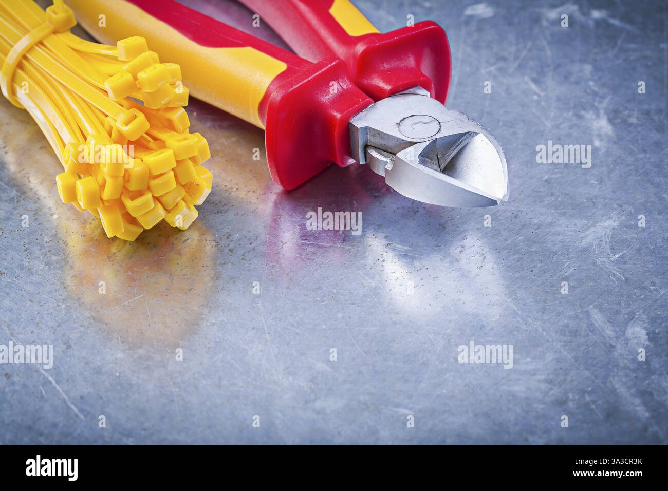 Wire-cutter cable ties on metallic background construction concept Stock Photo