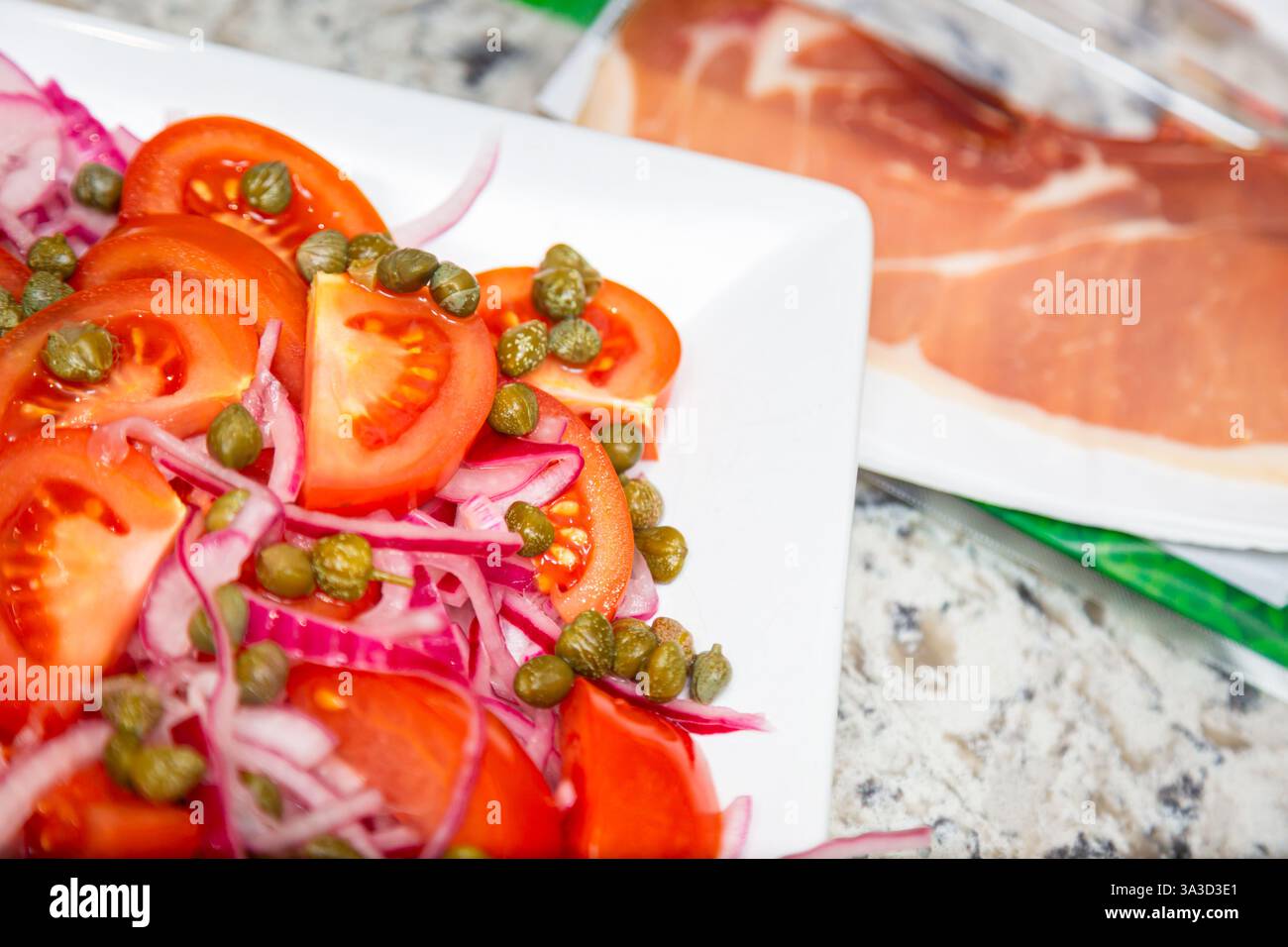 Fresh salad of tomatoes, onions and capers Stock Photo
