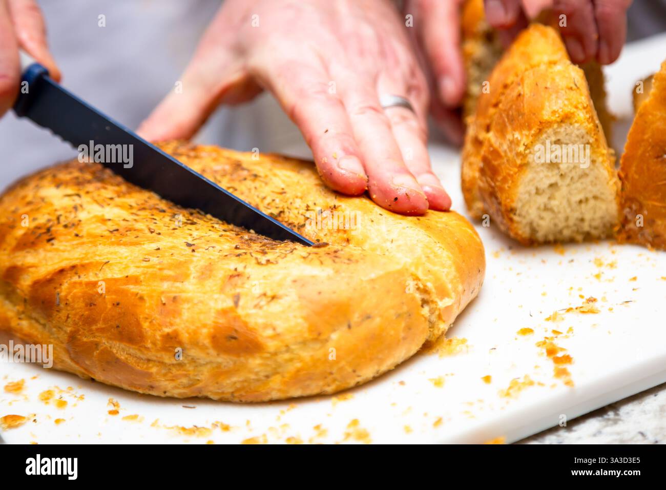 Home made Spanish bread being cut with a knife Stock Photo
