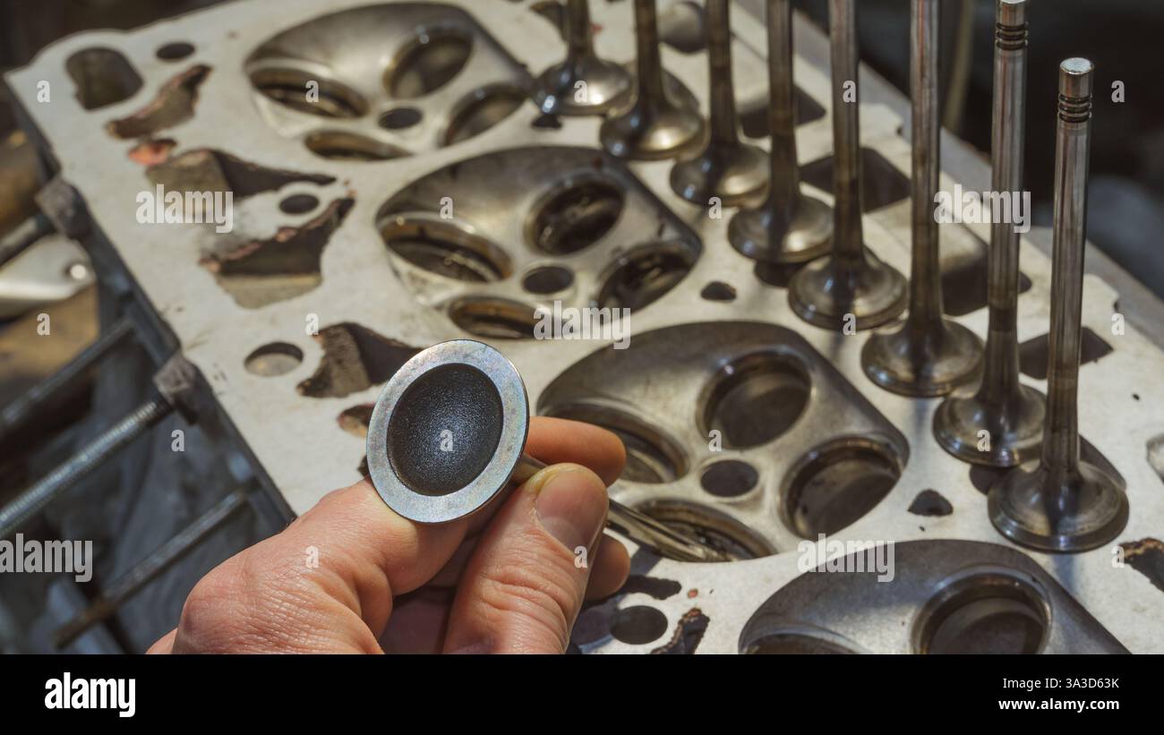 The hand of mechanic hold car engine valves close up.Part of car's ...