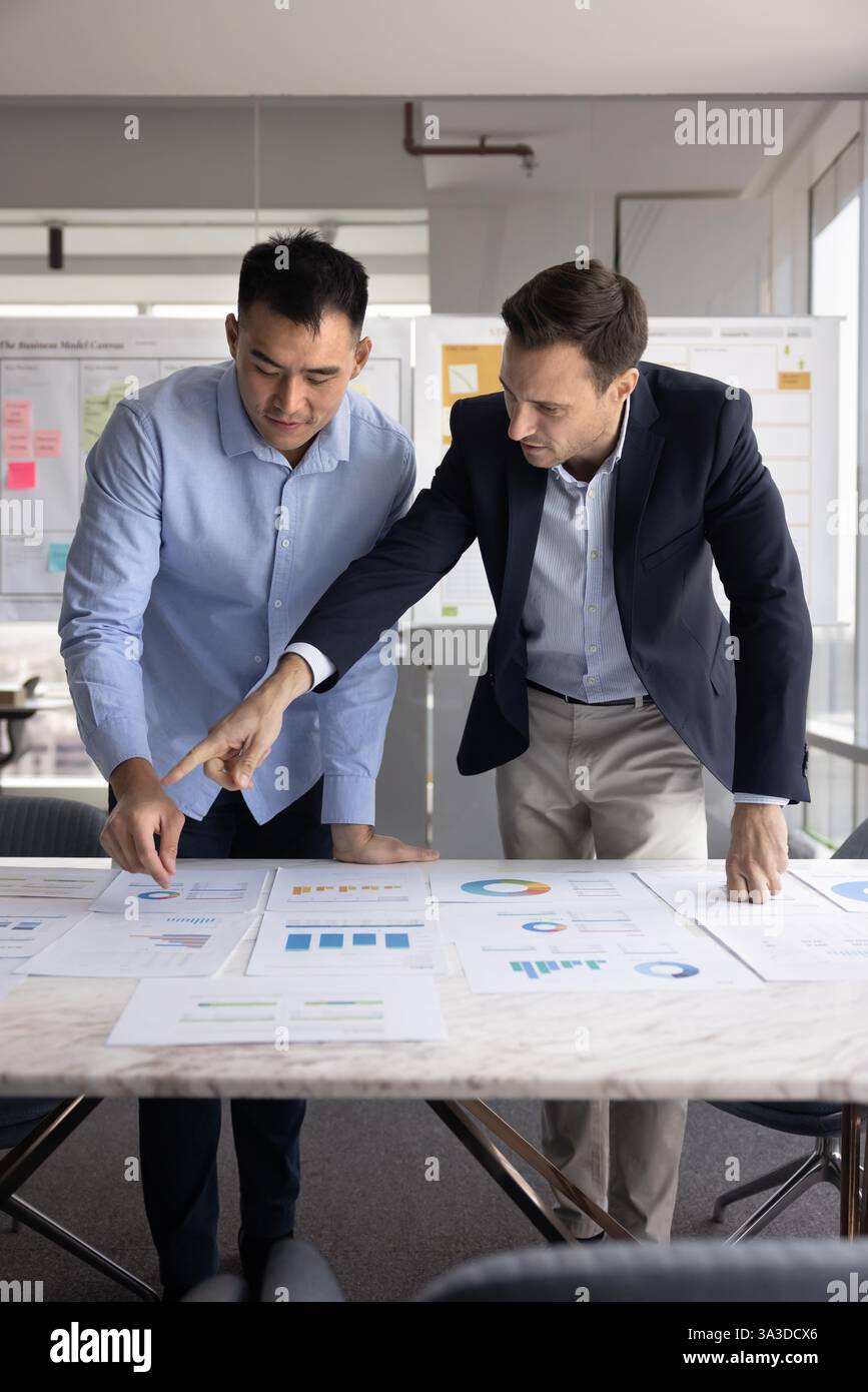 Two diverse project managers analyzing marketing research results Stock Photo
