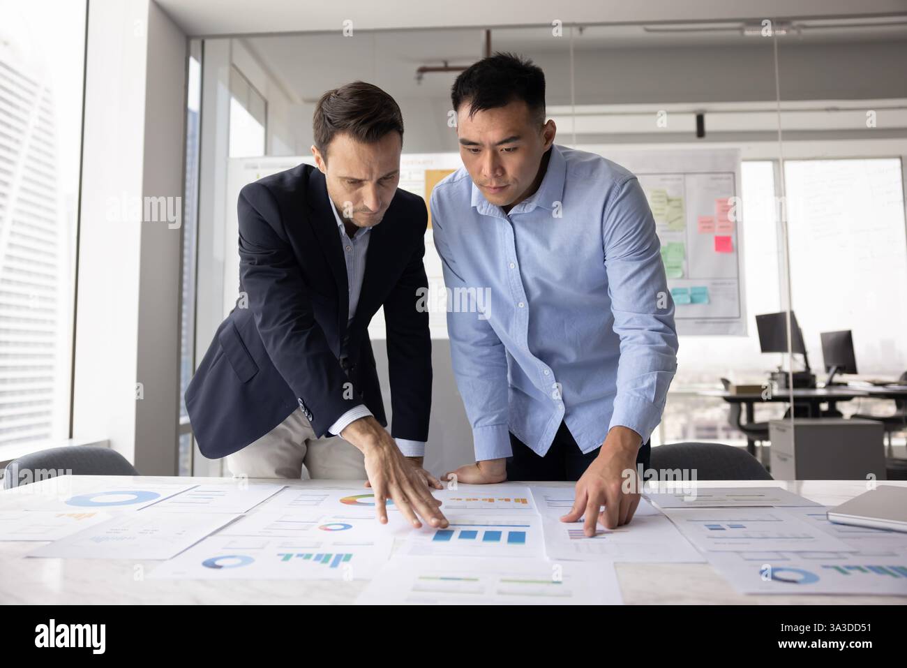 Two multiethnic businessmen developing marketing strategy for project Stock Photo