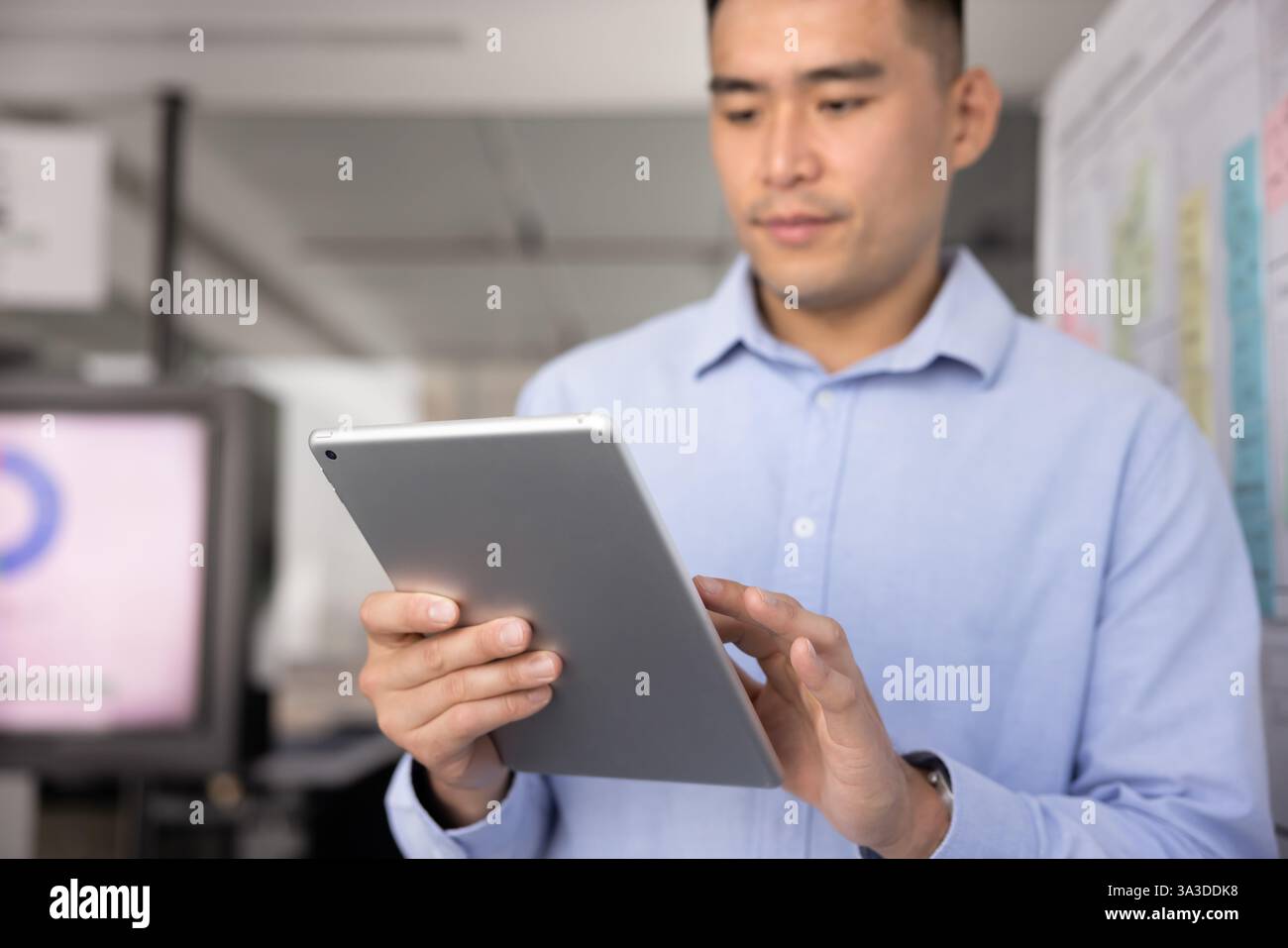 Focused young Asian business professional man using Internet technology Stock Photo