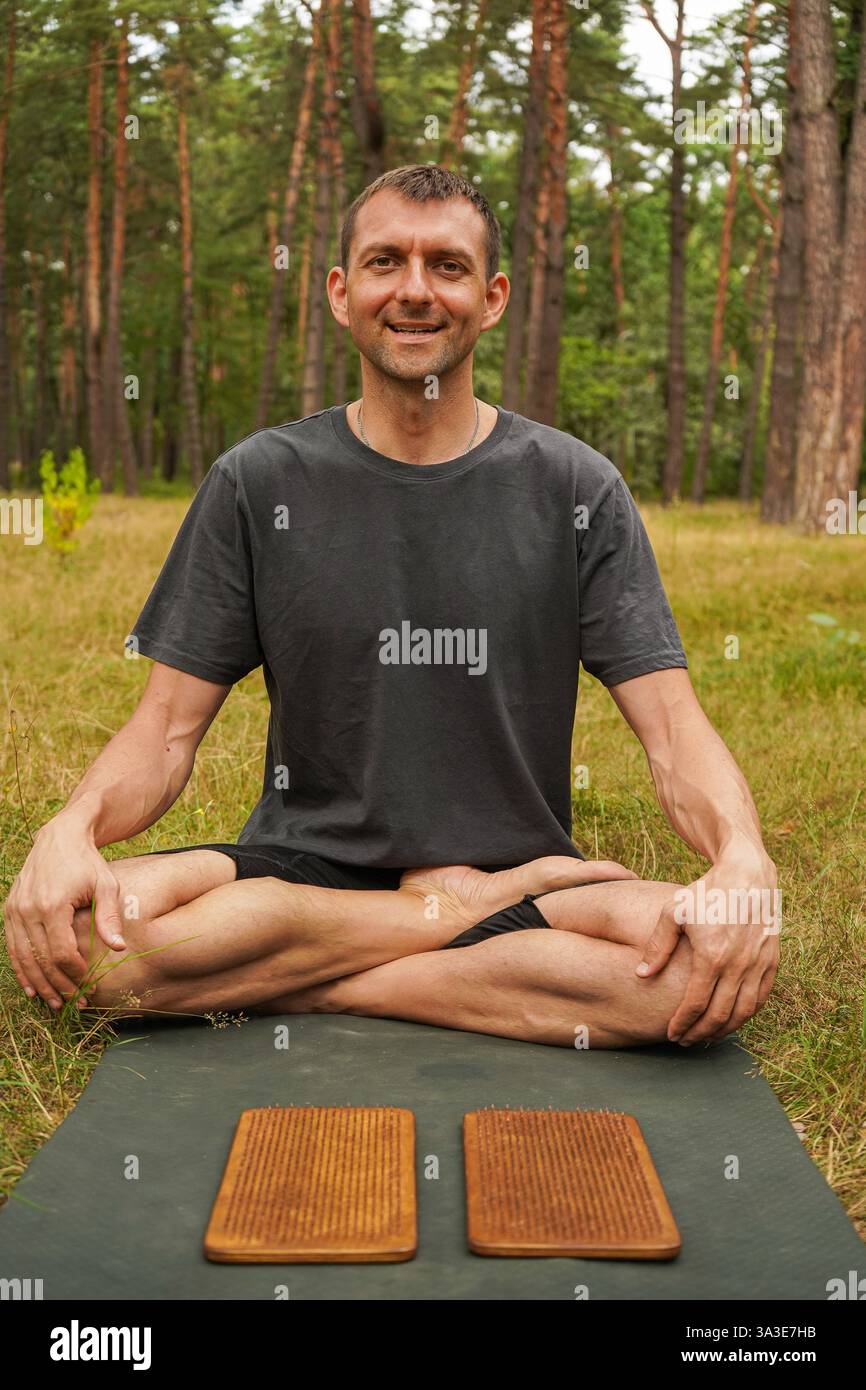 Peace and connection with nature. A man sits cross-legged in the lotus ...