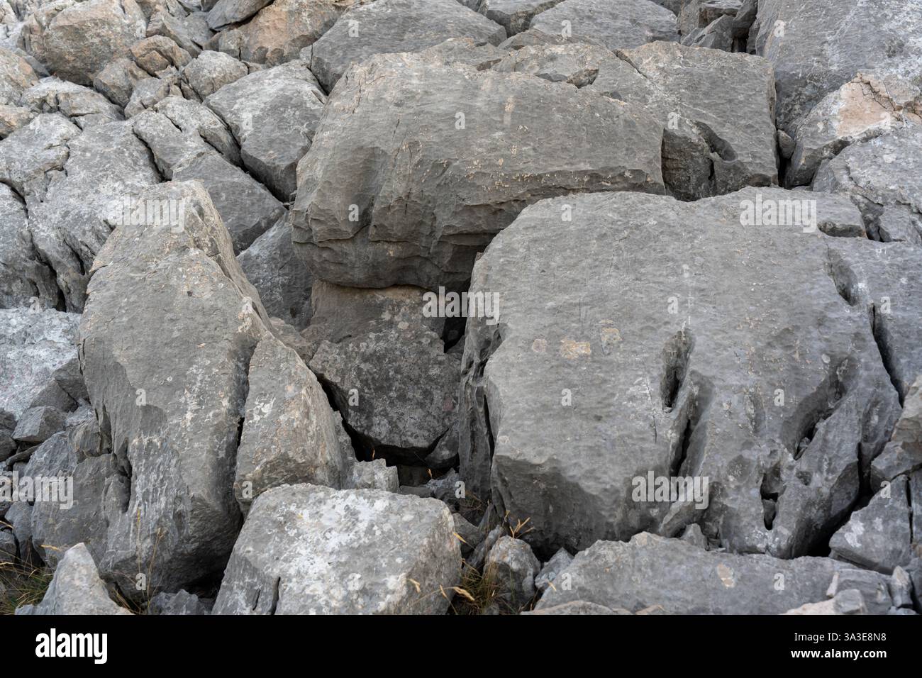 Detailed view of rugged gray rock formations with deep fissures and ...