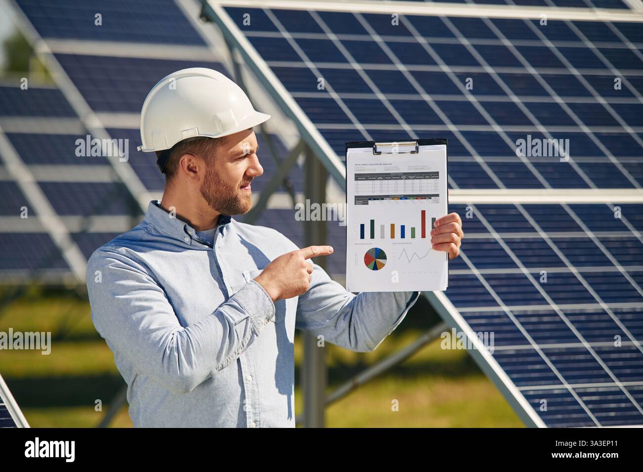 Pointing to the notepad with diagrams and graphs. Engineer with ...
