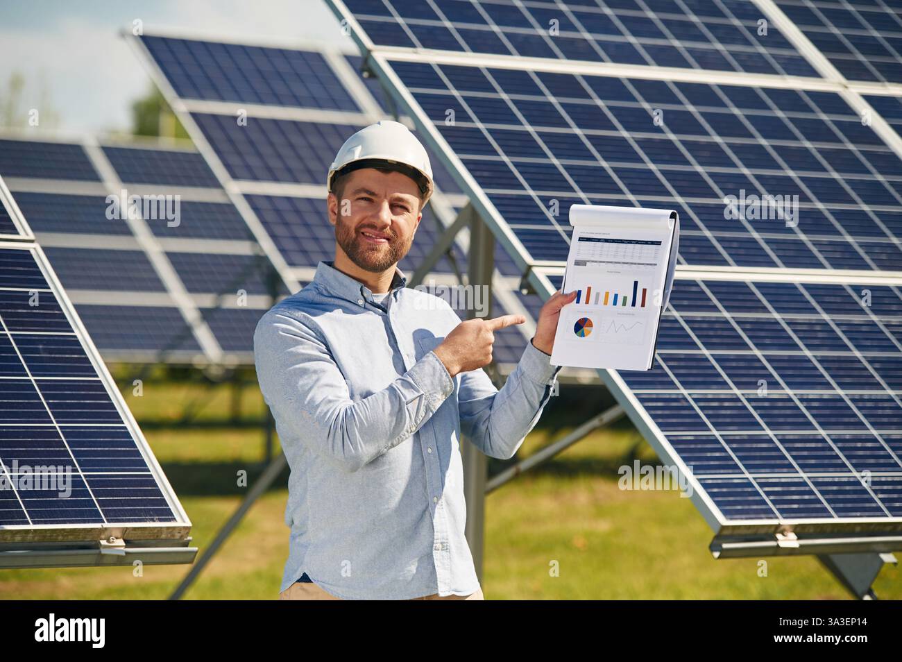 Pointing to the notepad with diagrams and graphs. Engineer with ...