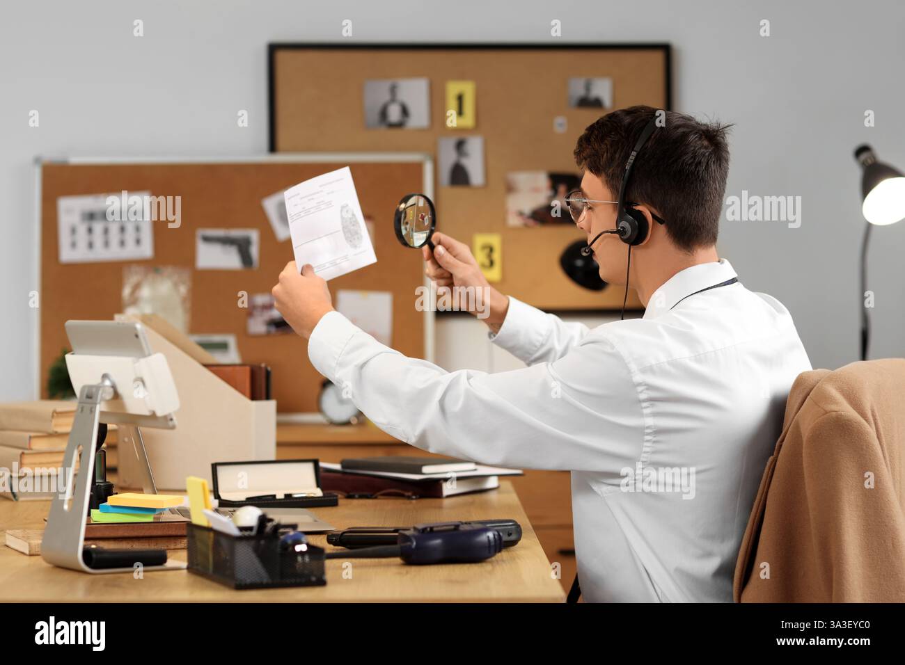 Male FBI agent in headset studying fingerprint at office, back view ...