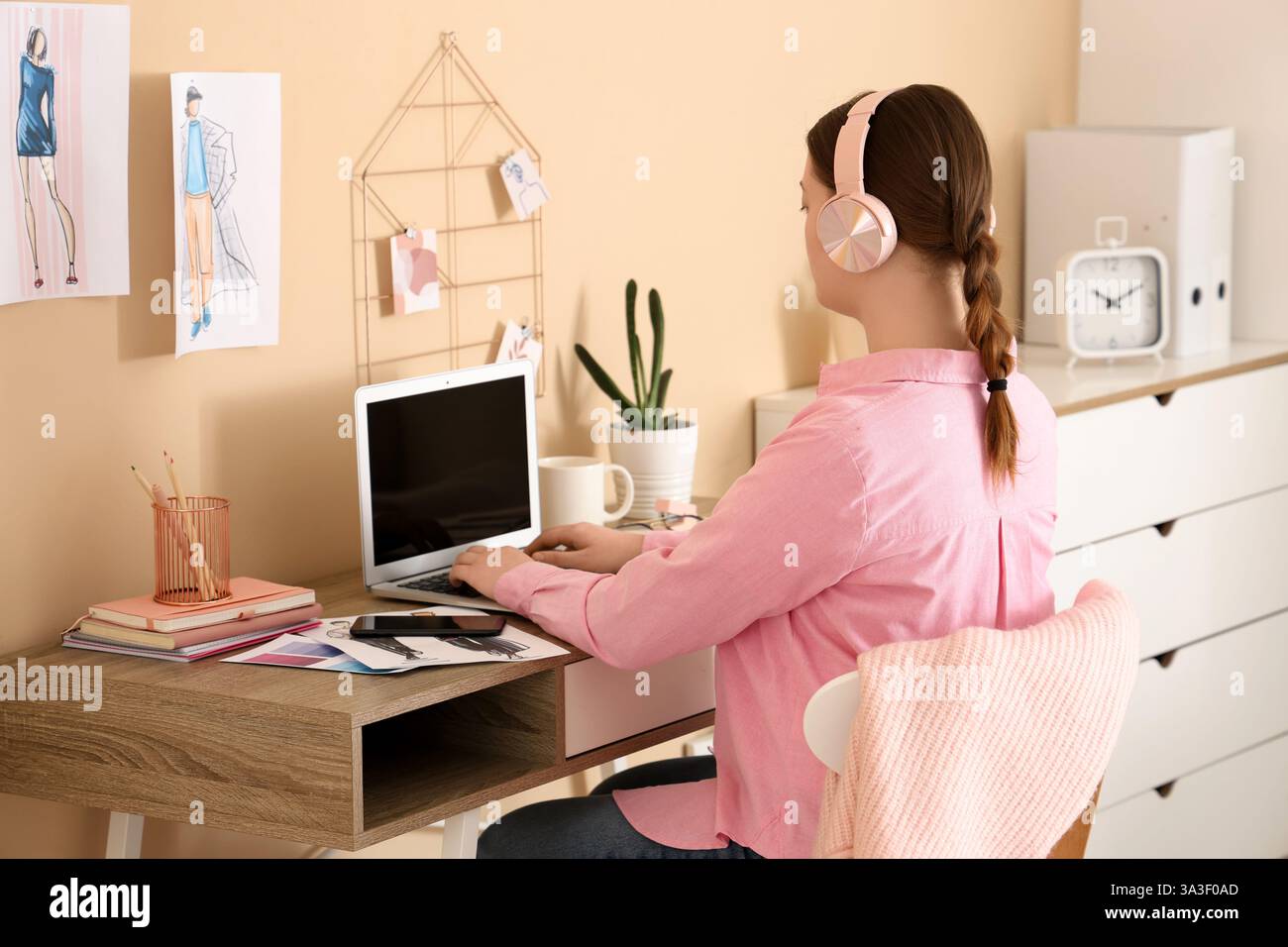 Female fashion designer working with blank laptop at table in office ...