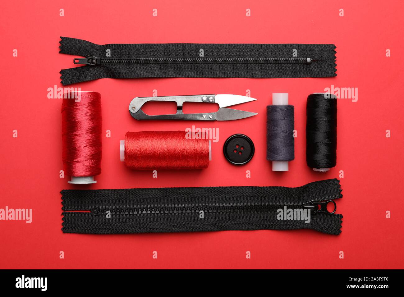 Different sewing supplies on red background, flat lay Stock Photo
