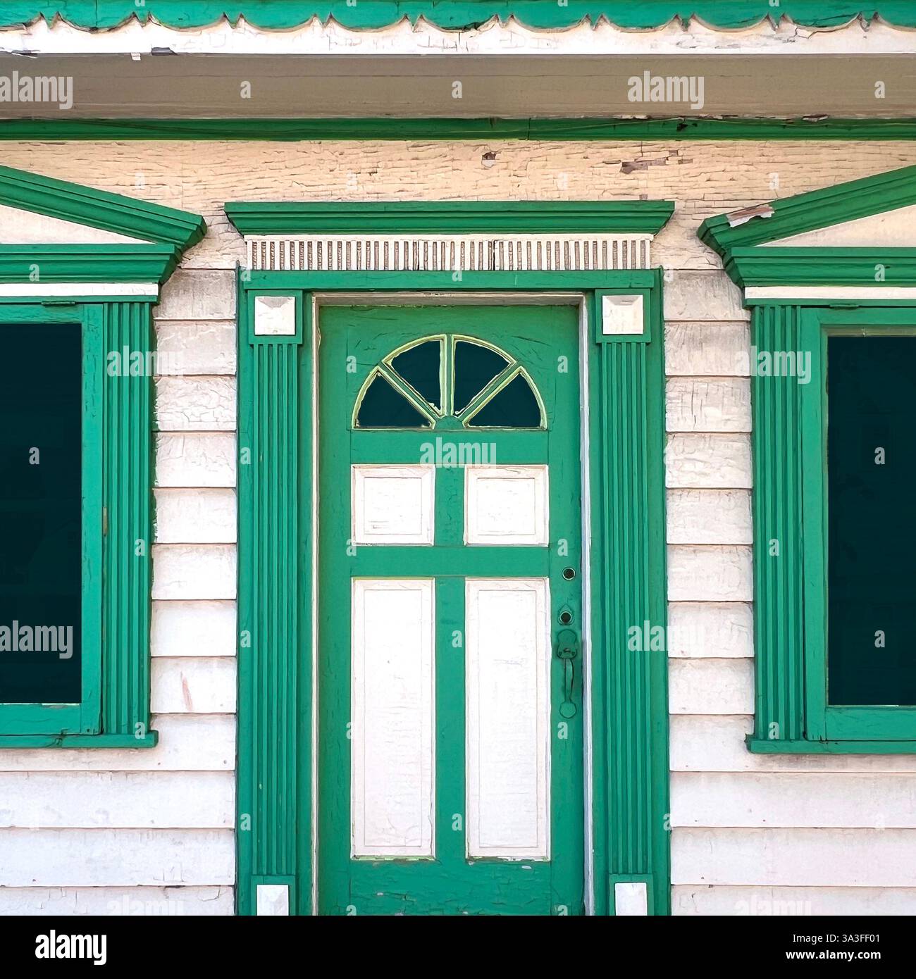 A beautifully preserved historic entrance featuring dual green doors framed by intricate molding, and ornate architectural details. - Smartphone Captured Stock Image