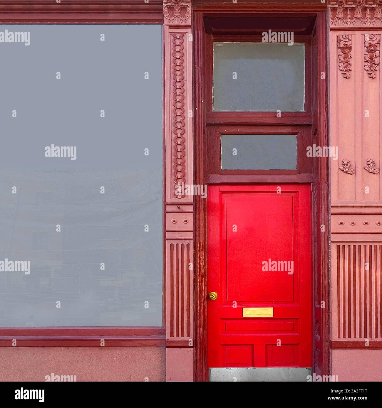 Red door set within an ornate historic storefront facade, featuring intricate wood detailing and decorative patterns, located in Chicago. - Smartphone Captured Stock Image