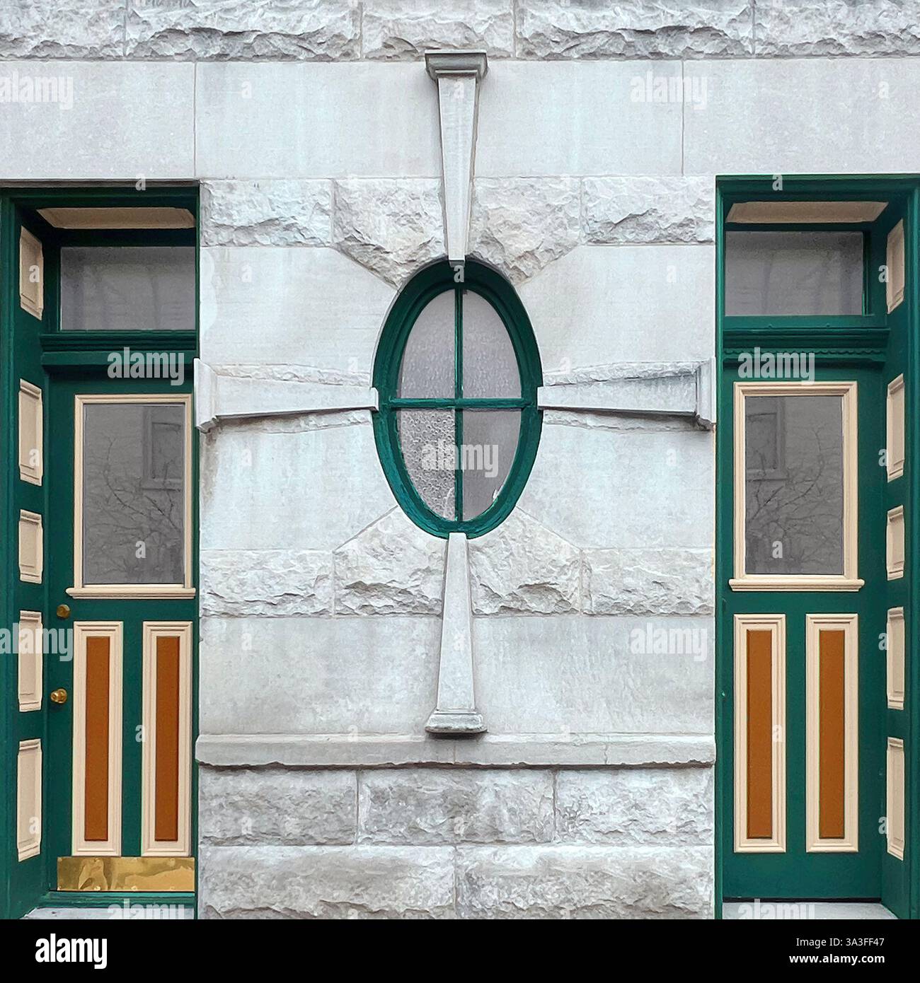 Symmetrical green and beige doors with an ornate oval window in a textured stone facade. - Smartphone Captured Stock Image