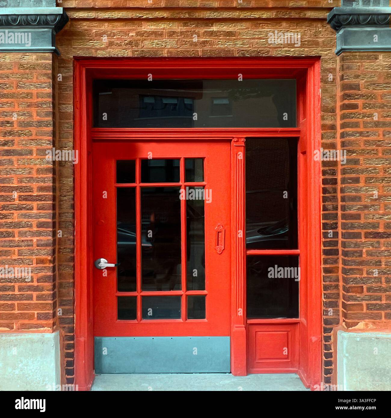 Red vintage doorway with glass panes, set against a rich brick facade, showcasing historic Chicago architecture - Smartphone Captured Stock Image