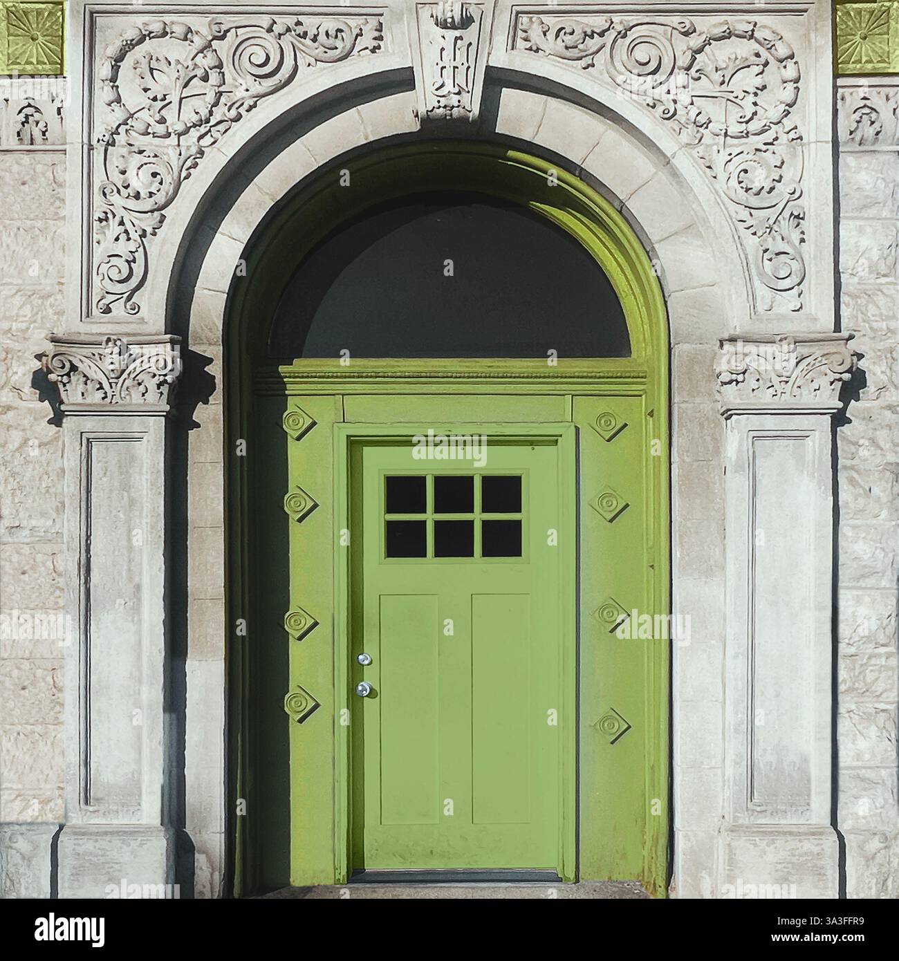 A vibrant green door framed by intricate stonework adds a bold pop of color to this historic Chicago facade. - Smartphone Captured Stock Image