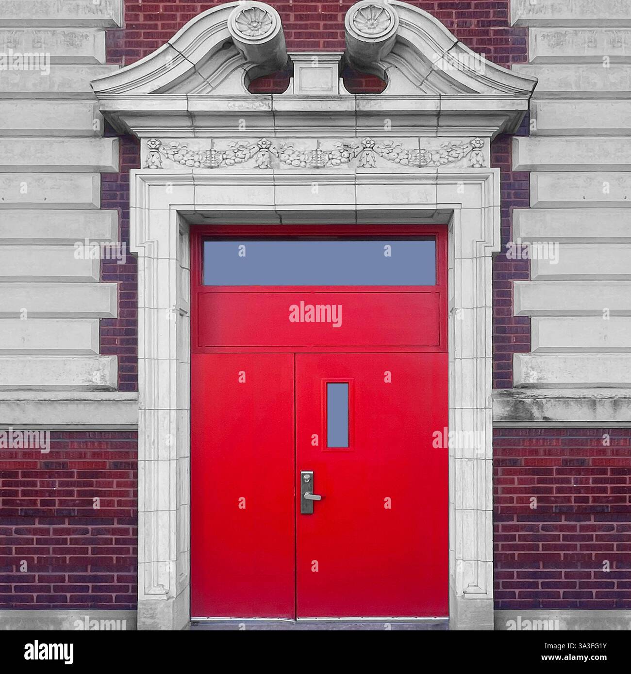 Red door set within an ornate neoclassical stone entrance, featuring intricate architectural details against a red brick and limestone facade. - Smartphone Captured Stock Image
