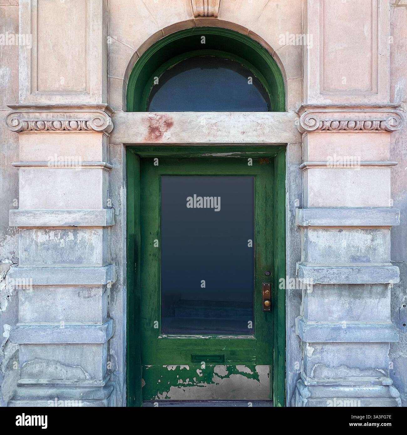 A weathered green wooden door with a large glass panel, framed by an ornate arched stone entrance. - Smartphone Captured Stock Image