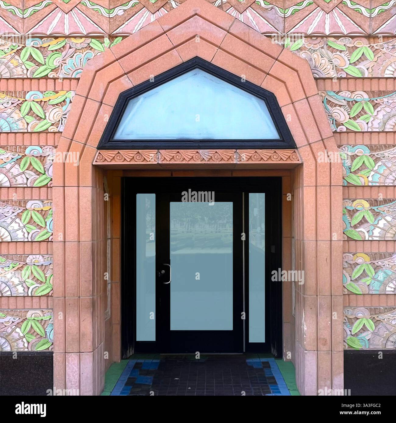 Art Deco entrance with intricate pastel-colored terra cotta floral tilework, geometric doorway, and decorative patterns, Chicago - Smartphone Captured Stock Image
