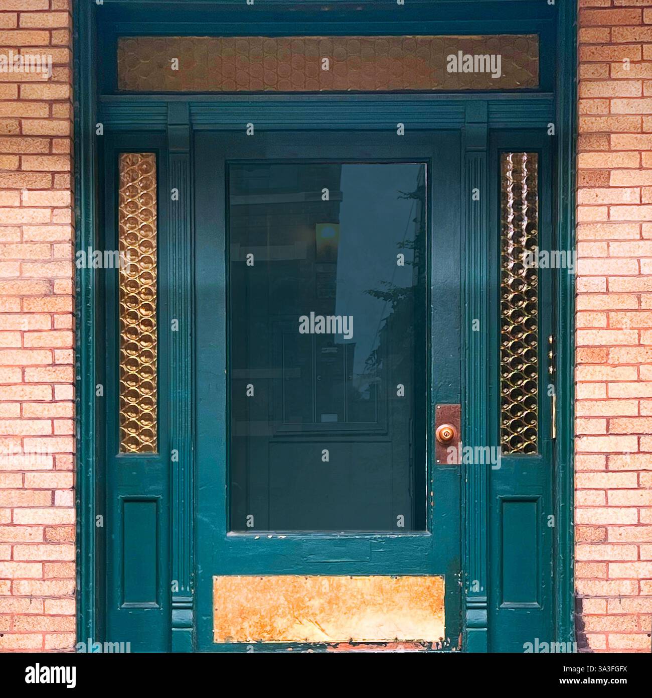 Teal entry door in Chicago framed by decorative amber glass panels and pink brickwork - Smartphone Captured Stock Image