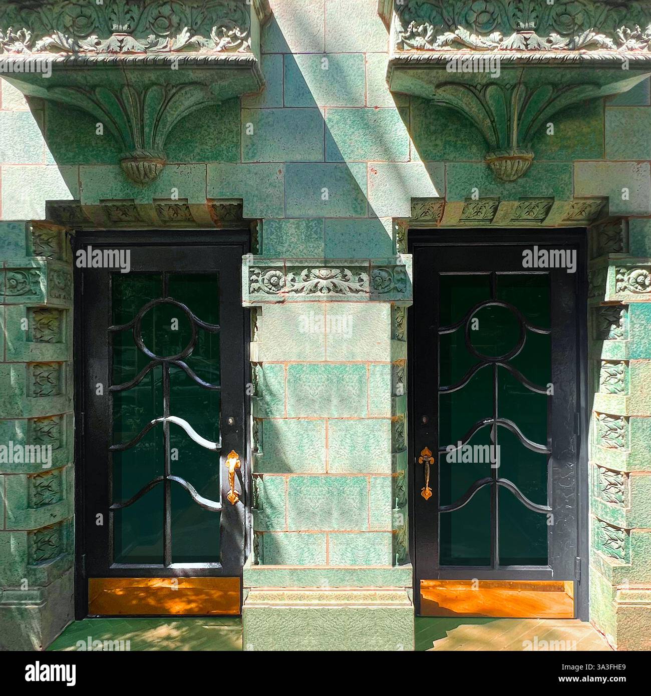 Ornate Doorway framed by intricate ironwork, set within a stunning green-glazed tile facade in Chicago. - Smartphone Captured Stock Image