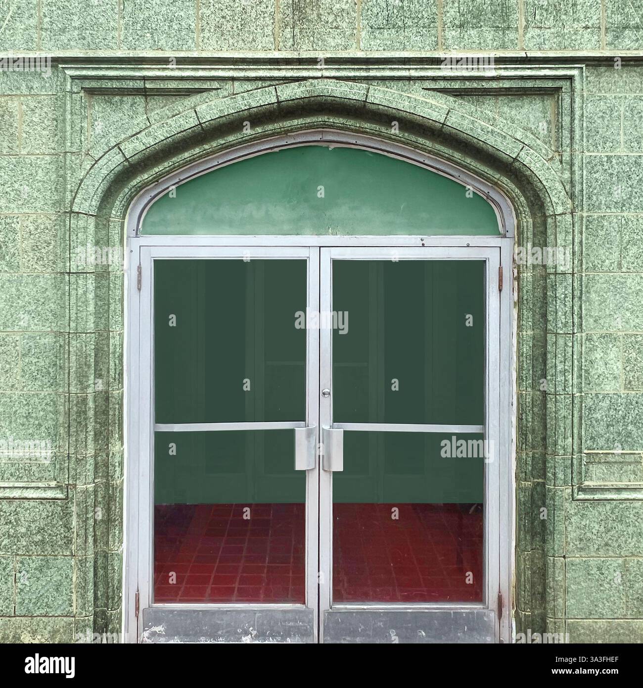 A vintage green stone building with an arched entrance in Chicago. - Smartphone Captured Stock Image