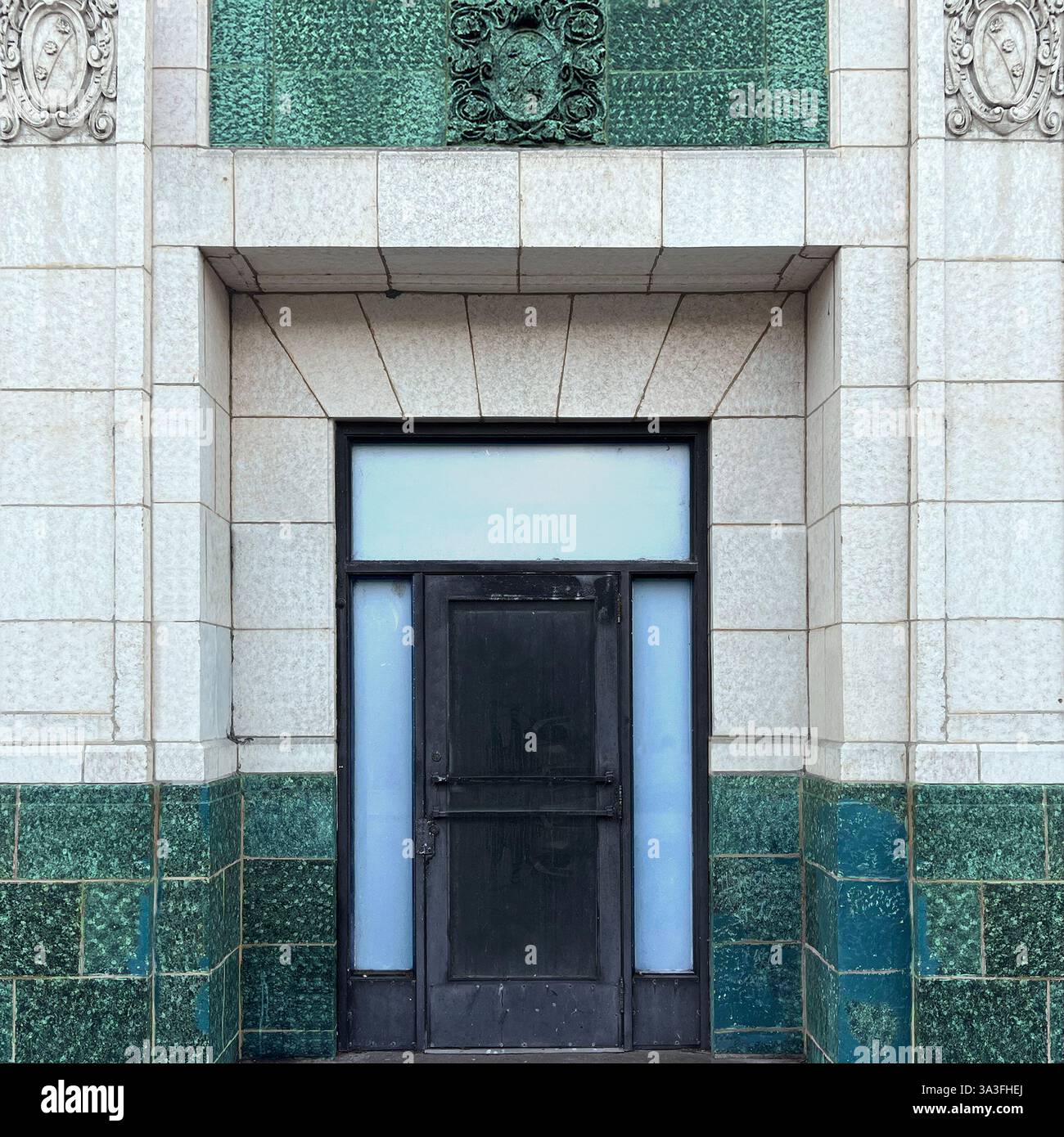 A historic doorway  framed by green and white architectural tilework,with ornate stone detailing in Chicago. - Smartphone Captured Stock Image