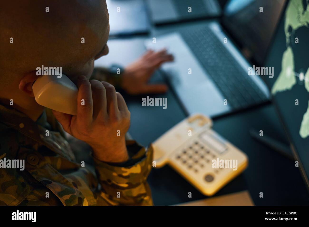 Soldier Analyzing Data on Multiple Computer Screens Stock Photo