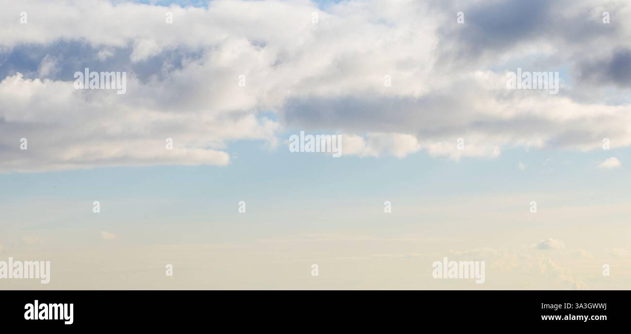 A peaceful view of a bright blue sky filled with fluffy white clouds ...