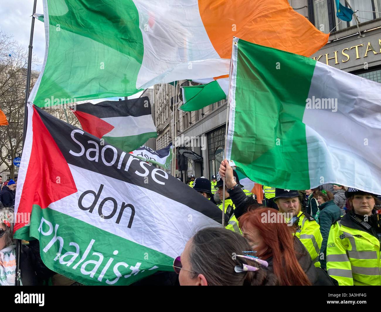 16 March 2025. London. St. Patrick's Day Parade: Police officers stop Irish supporters of Palestine continuing along the official route of the parade. - Smartphone Captured Stock Image