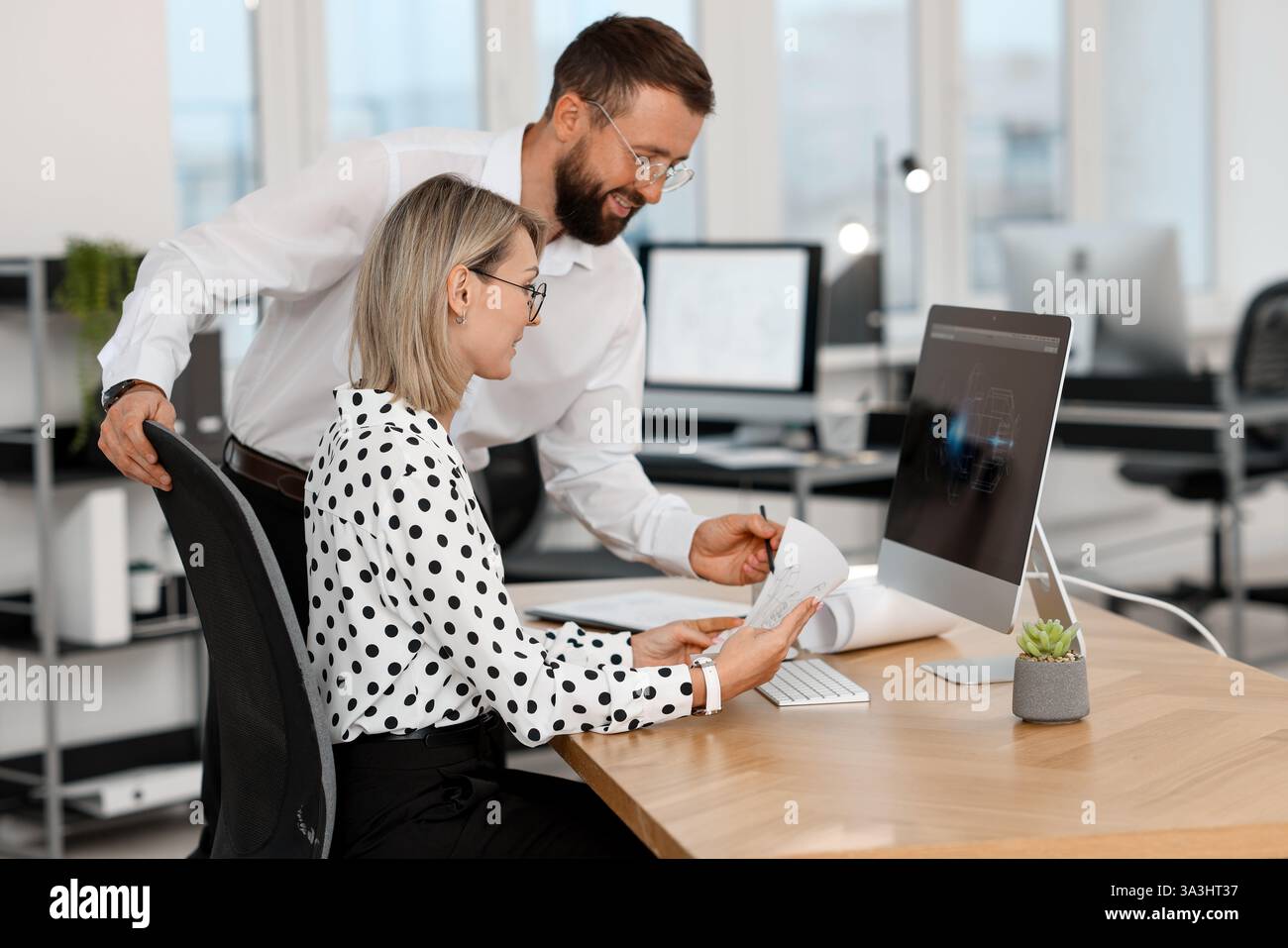 Technicians making digital engineering drawing on computer at desk in office Stock Photo