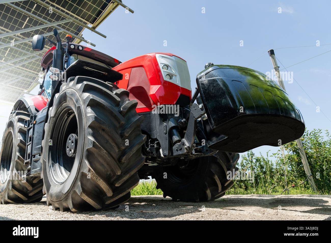 Red tractor on a farm using renewable energy. Stock Photo