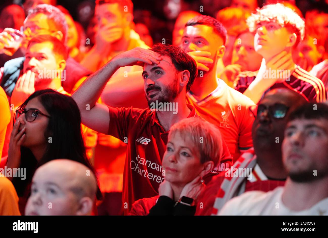 Liverpool fans react after their side conceded a goal as they watch the ...