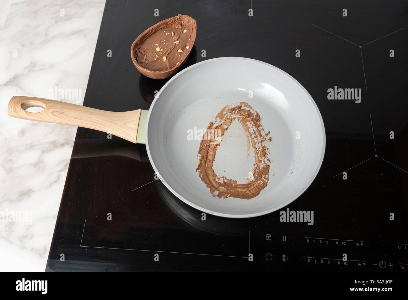 Frying pan with chocolate stain from half an Easter egg. Stock Photo