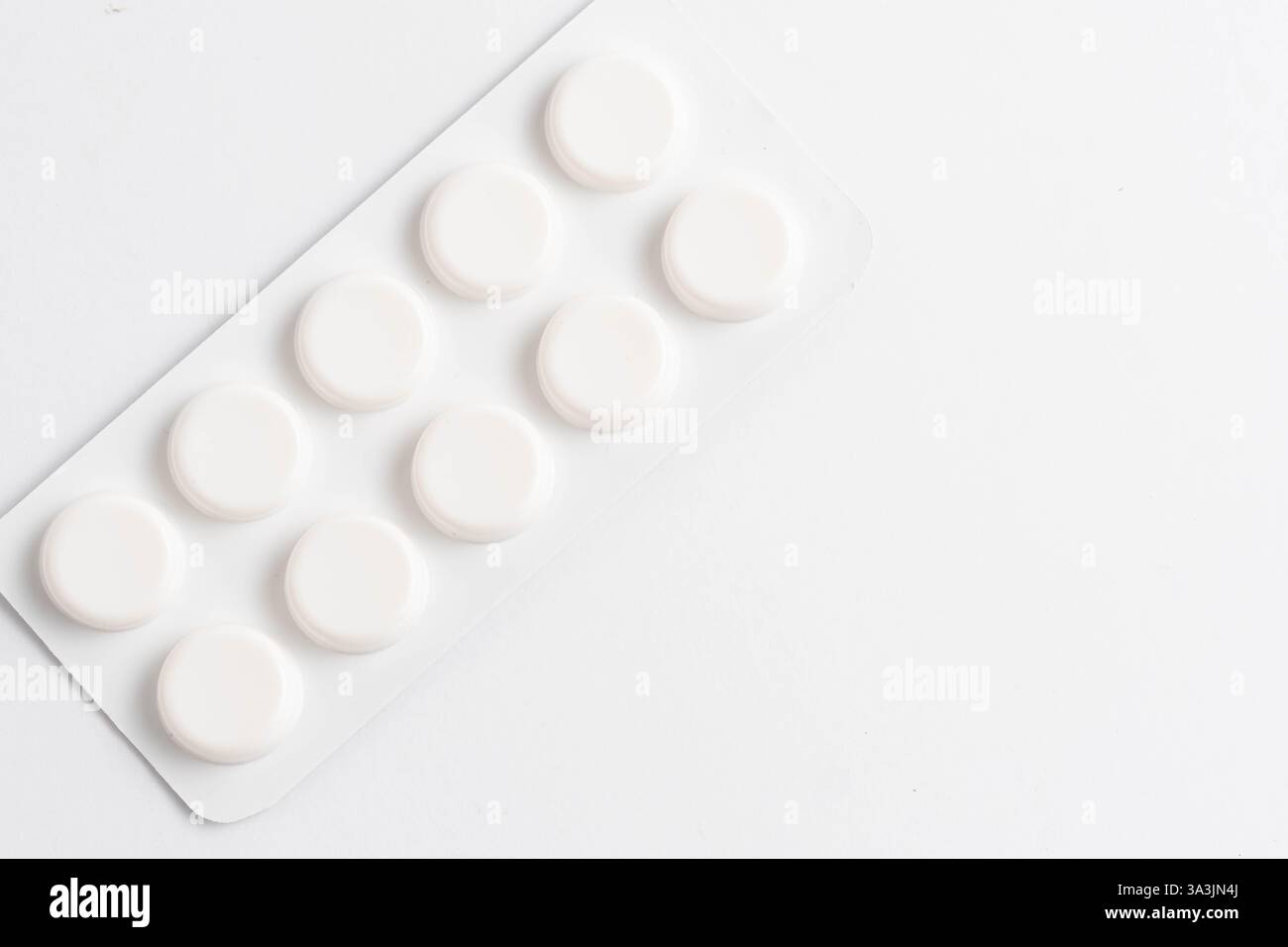 White pills on white background. Top view. Copy space Stock Photo