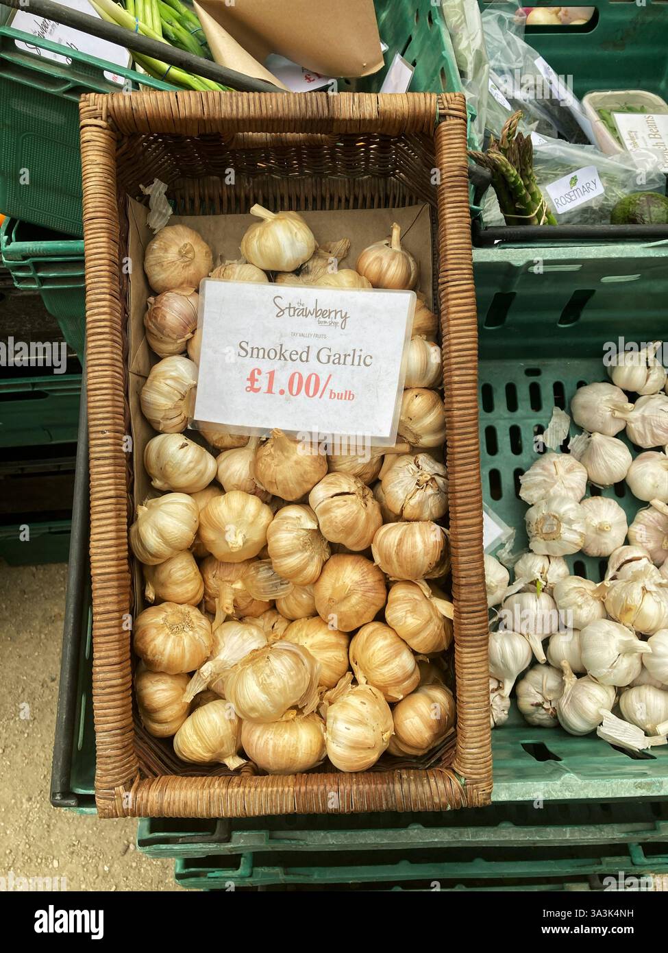 Speciality Smoked Garlic bulb priced up for sale at local farmers market stall - Smartphone Captured Stock Image